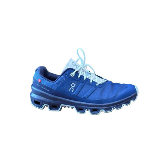 Blue athletic shoe with white laces on a white background